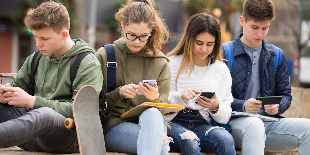 Teenagers chatting on their smartphone on walking