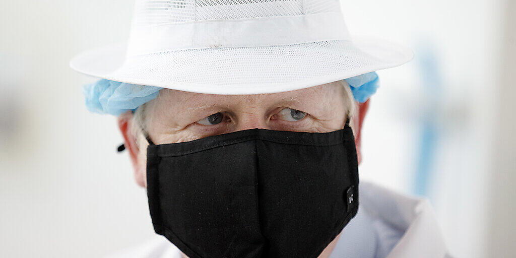 Boris Johnson, Premierminister von Großbritannien, trägt Schutzkleidung und einen Mundschutz bei einem Besuch der Orkney Cheese Company. Foto: Robert Perry/PA/dpa