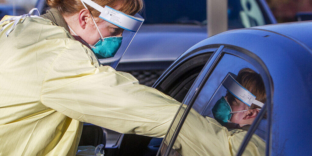 ARCHIV - Eine Mitarbeiterin des Gesundheitswesens führt einen Corona-Test bei einem Patienten auf dem Parkplatz des Saint Alphonsus Health Plaza durch. Foto: Darin Oswald/Idaho Statesman/AP/dpa